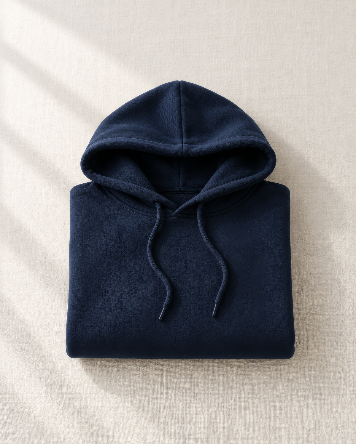 Gefalteter marineblauer Hoodie auf hellem Leinen